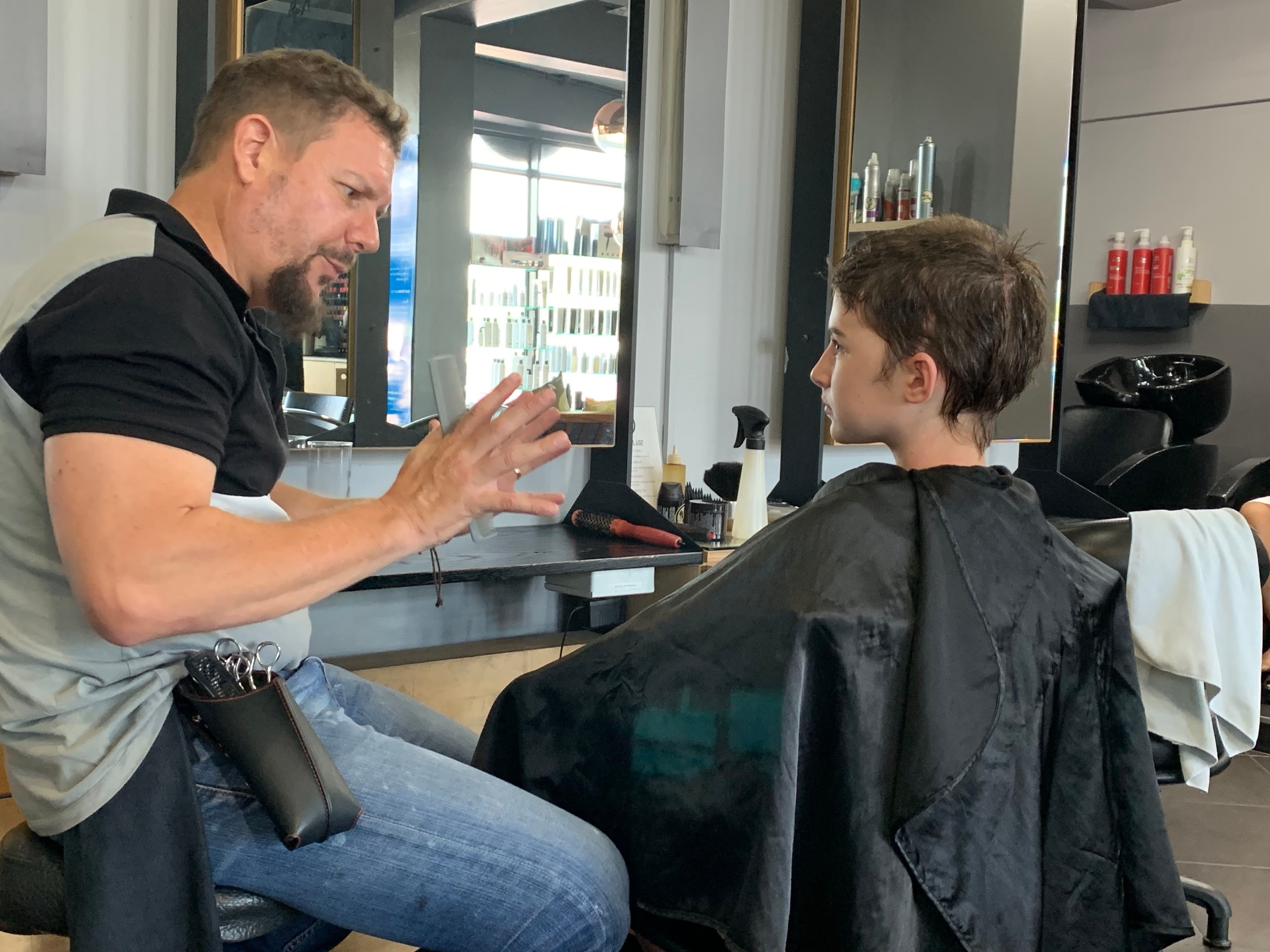 The hairdresser taking his time to explain to Kiara exactly how he was going to make her look gorgeous for every step of growth. He has his work cut out for him, as half her head is has grown back with curls, and the other half is straight!